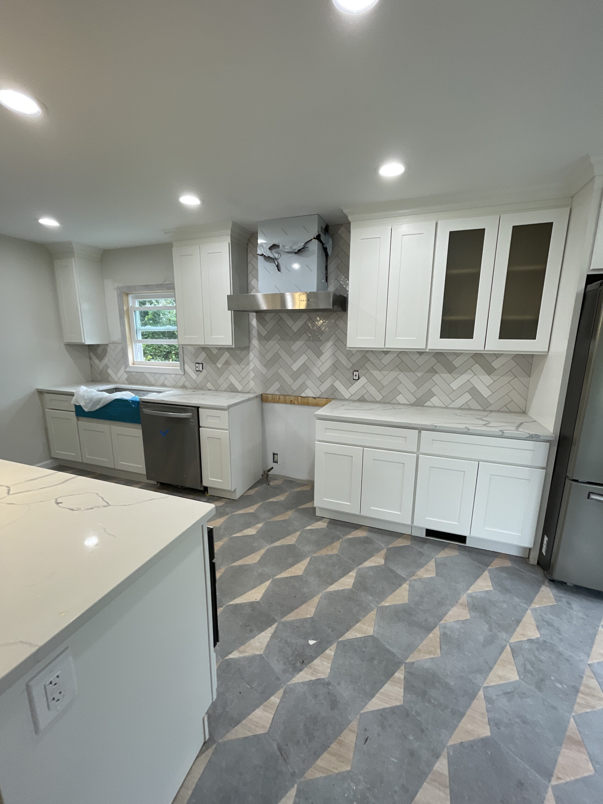 Kitchen remodel — gray cabinets with herringbone backsplash
